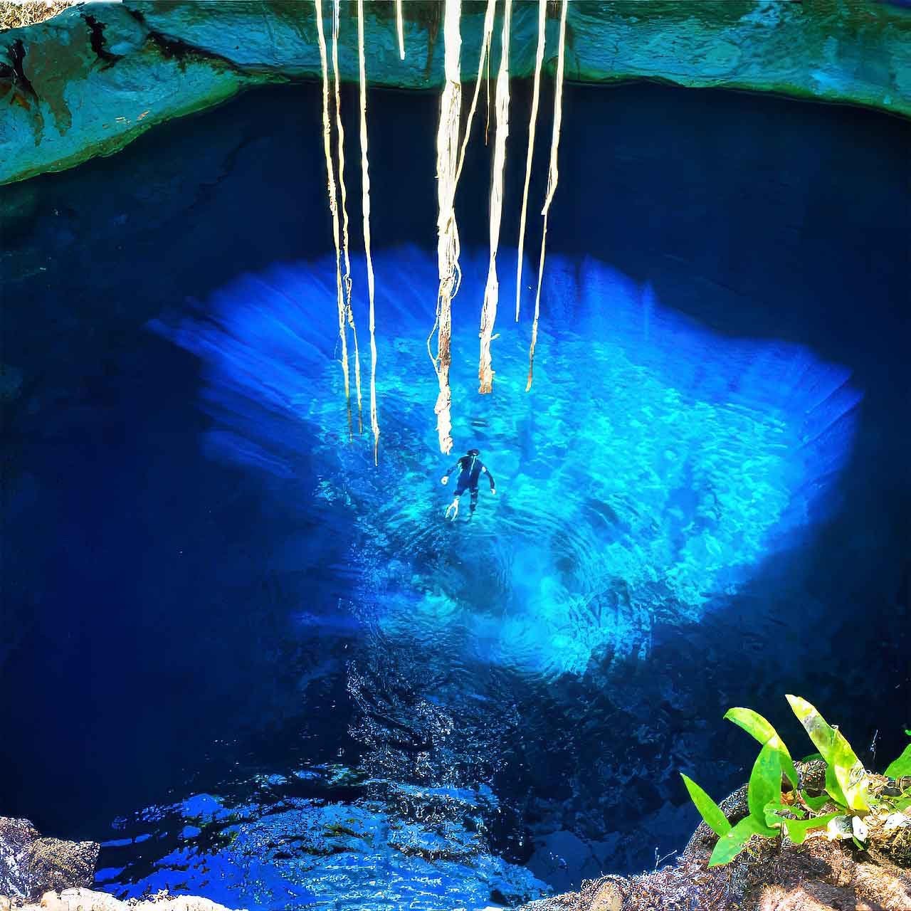 Man enjoying a private blue cenote in Yucatán during a luxury cultural tour in Mexico.