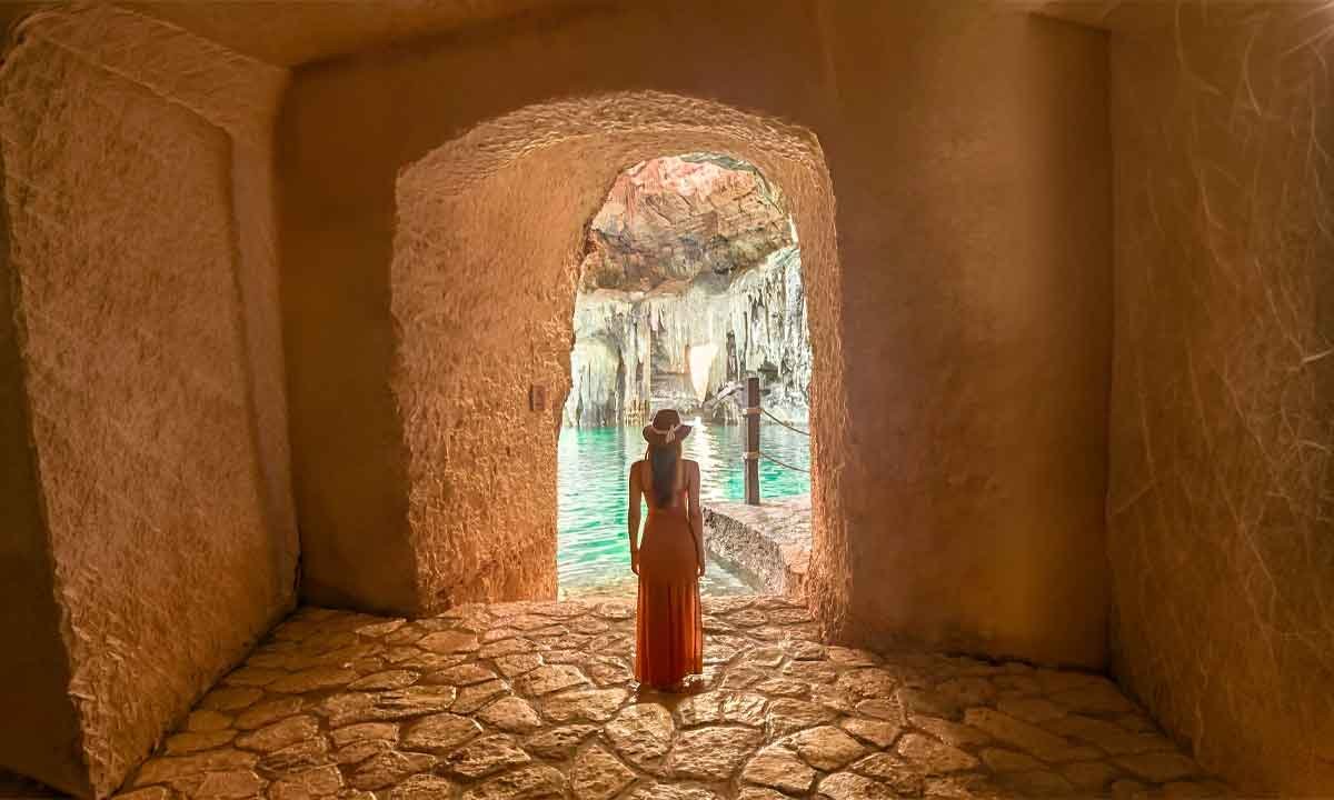 Traveler entering a cenote with turquoise water, showing thoughtful comfort and nature on a private Mexico journey.