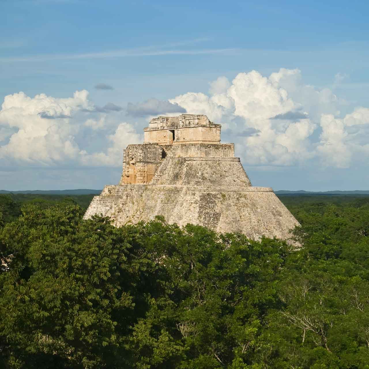 Uxmal - authentictravelmexico.com Uxmal pyramid rising above the forest, a highlight of private Yucatán journeys focused on Maya heritage and archaeology.